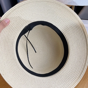 Close-up of beige woven straw hat showing fine spiral texture and inner black sweatband