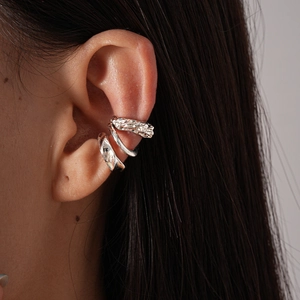 Detailed view of silver non-pierced ear cuffs with textured and smooth geometric finishes