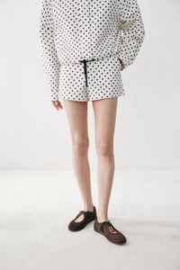 Detail von weißem Polka-Dot-Hausanzug mit Kordelzug-Shorts und elastischem Hosenbund