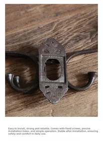 Close-up of vintage cast iron coat hook with rustic bronze finish on aged wood