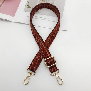 Adjustable woven shoulder strap with red and brown chevron pattern and gold metal hooks
