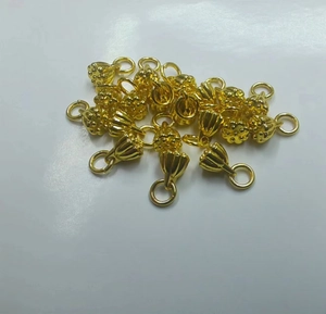 Close-up of golden lotus flower bud pendants with shiny finish for jewelry making