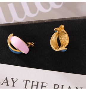 Detail of vintage double leaf stud earrings with pink and blue enamel and gold plating