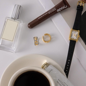 Flat lay of celestial star and moon 18K gold stainless steel rings with elegant lifestyle props