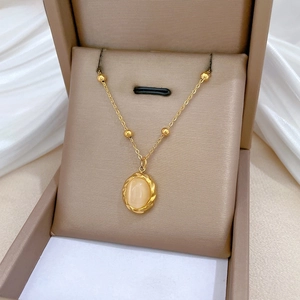 Detailed close-up of a rotating cat eye stone pendant with a vintage gold twist frame