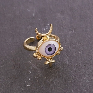 Close-up of 18K gold evil eye ring with purple stone, crescent moon and star detail