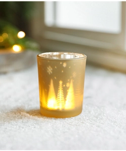 Detail of amber glass Christmas candle holder with etched snowflake and tree patterns
