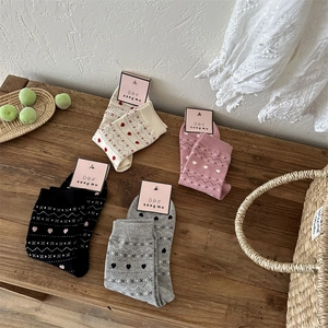 Gros plan de chaussettes en coton à motif de cœur en plusieurs couleurs et maille rétro