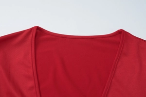 Gros plan du décolleté de la robe rouge montrant la double couture et la texture du tissu