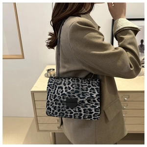 Sac bandoulière chic à imprimé léopard avec chaîne métallique sur un blazer neutre