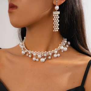 Close-up of a model wearing an elegant baroque pearl necklace with sparkling rhinestone fringe