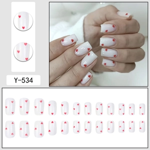 Press-on nails in cream white with red heart patterns on square-round shape tips