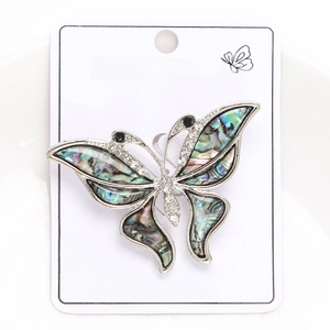 Macro view of butterfly brooch with iridescent abalone shell wings and crystal details