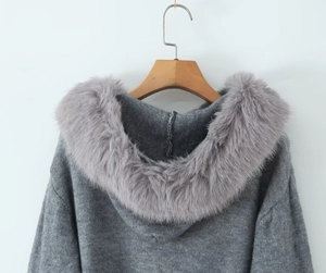 Detailed view of gray hooded cardigan featuring a thick faux fur collar on wooden hanger