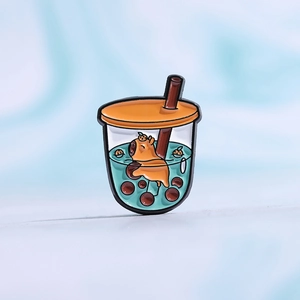 Macro detail of a creative enamel capybara bubble tea brooch with orange lid and straw