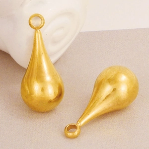Macro shot of polished gold-tone teardrop pendant charms for DIY jewelry making