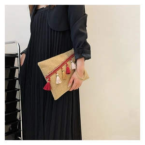 Close-up of bohemian woven clutch with colorful tassels and ethnic ribbon detail