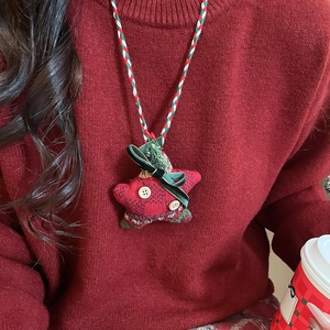 Detail of a Christmas star plush pendant with red plaid fabric and wooden button decor