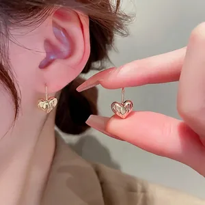 Textured gold heart earrings with vertical pleats and elegant French hook design