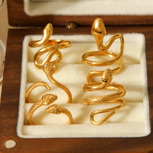 Macro shot of 18K gold plated snake rings with scale textures and zircon in a wood box