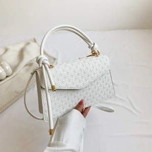 Textured white crossbody underarm bag with gold hardware and knotted top handle