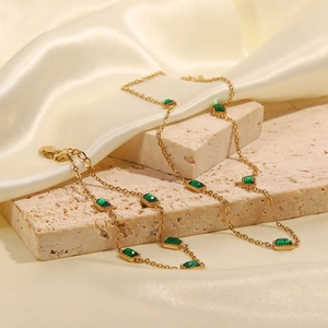 Golden titanium steel necklace with square emerald zircons on beige stone with ivory silk