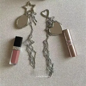 Detailed view of heart and star mirror pendants with geometric beaded metal tassels