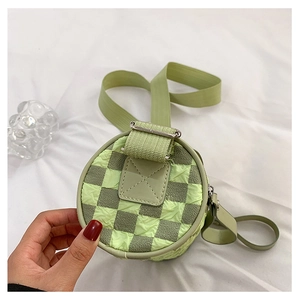 Detailed shot of green checkerboard cylinder bag with bubble fabric and adjustable strap
