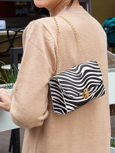 Mini zebra print chain crossbody bag shown on a model for scale and urban styling