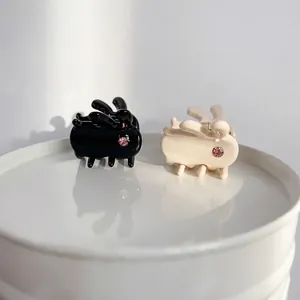 Mini acetate rabbit hair claw clips in black and cream white with pink rhinestones