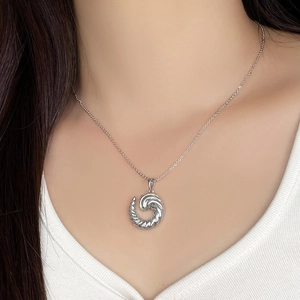 Close-up of a silver twisted spiral pendant necklace worn on a neck for a modern look