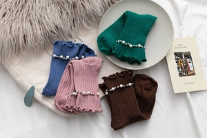 Detail of ruffled crew socks with pearl and rivet studs in multiple colors