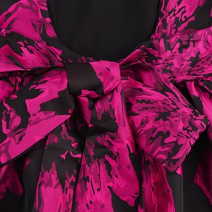 Elegant backless jacquard dress with large bow and vibrant pink floral pattern