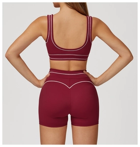Detail view of burgundy yoga set with white contrast piping and U-back design