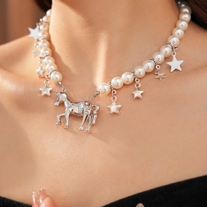 Detailed view of pearl choker necklace featuring silver horse and star pendants