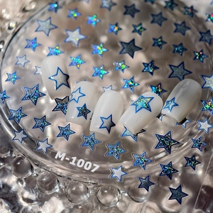 Macro shot of M-1007 blue and silver laser star nail stickers on white press-on nails