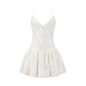 Detailed macro view of white V-neck dress with floral jacquard fabric and pleated texture