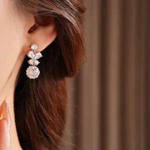 Boucles d'oreilles papillon en argent avec pendentif sphère en cristal sur un modèle