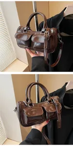 Detail of vintage dark brown glossy leather saddle bag with double front pockets
