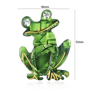 Detailed view of green acrylic frog brooch with rhinestone eyes measuring 40mm by 55mm
