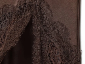 Détail de tissu en satin marron avec une bordure en dentelle délicate et texture soyeuse