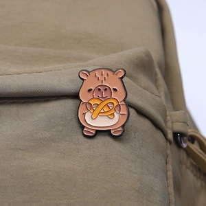 Detail einer süßen Wasserschwein Emaille-Anstecknadel auf einem Khaki-Rucksack