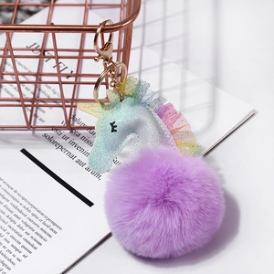 Llavero de unicornio brillante con pompón de piel violeta y encaje arcoíris para bolso
