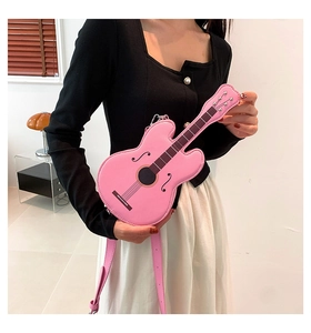 Detailed view of pink violin-shaped crossbody bag with adjustable strap and leather texture