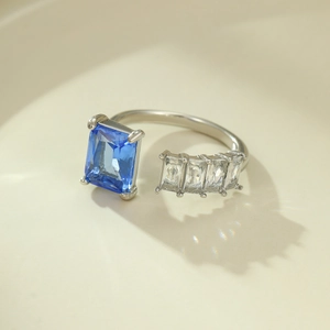Close-up of silver steel ring featuring blue rectangular gemstone and clear zircon stones