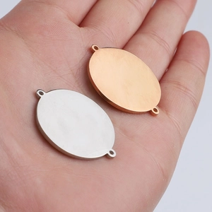 Polished silver and rose gold oval connectors for DIY jewelry making shown in hand