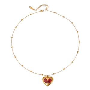 Collier en acier doré à perles avec deux cristaux rouges en forme de goutte formant un coeur