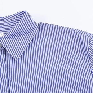 Gros plan du col de chemise à rayures bleues et blanches avec coutures précises et texture