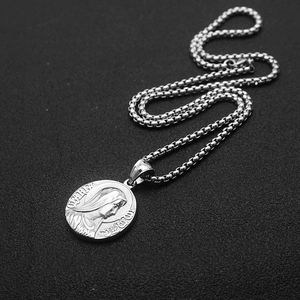 Detailed view of Virgin Mary embossed pendant with box chain on black background