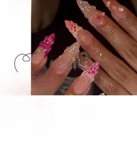Détail de faux ongles stiletto roses avec papillons 3D, perles et effet dégradé
